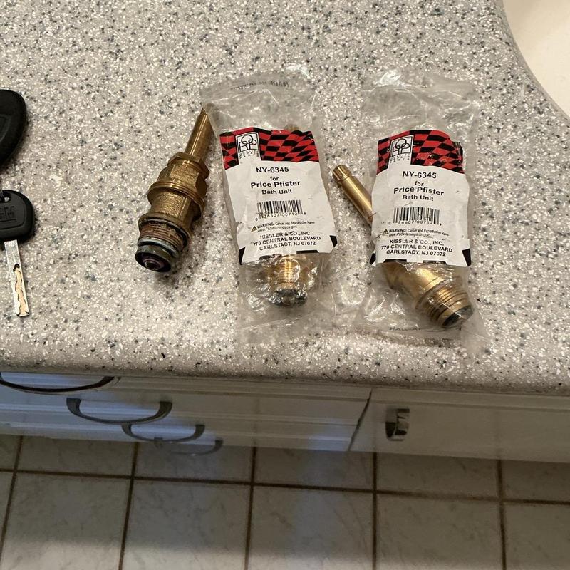 Shower valve cartridges on countertop, new and old Shower valve cartridges on countertop, new and old