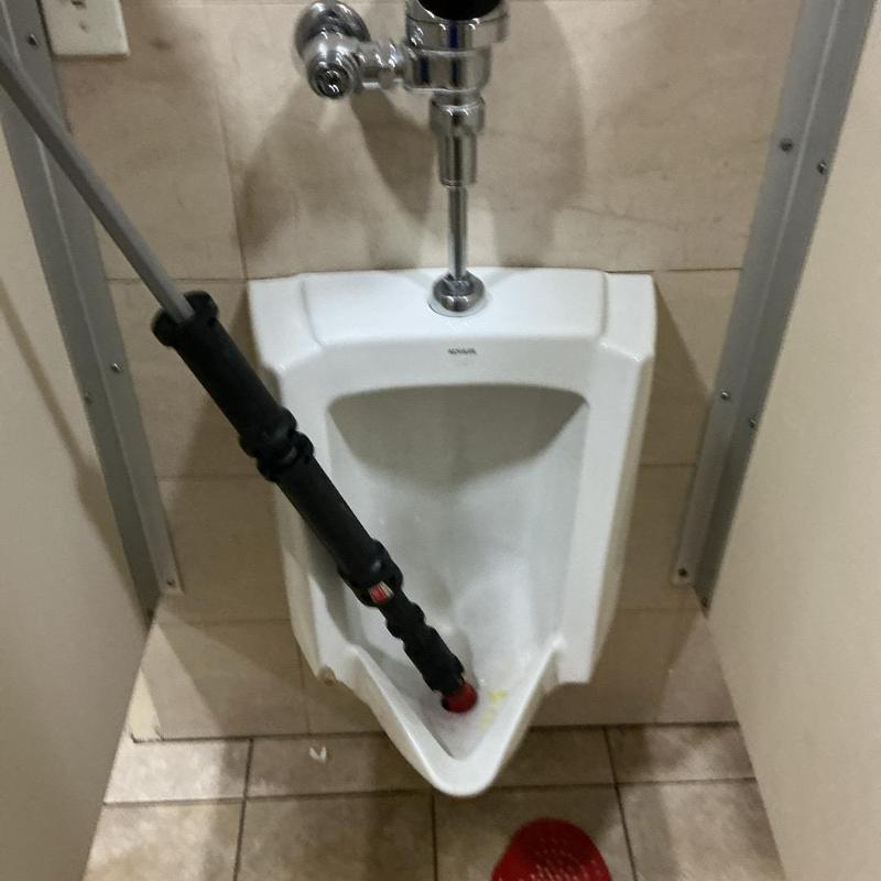 Urinal drain cleaning with hand auger tool Urinal drain cleaning with hand auger tool