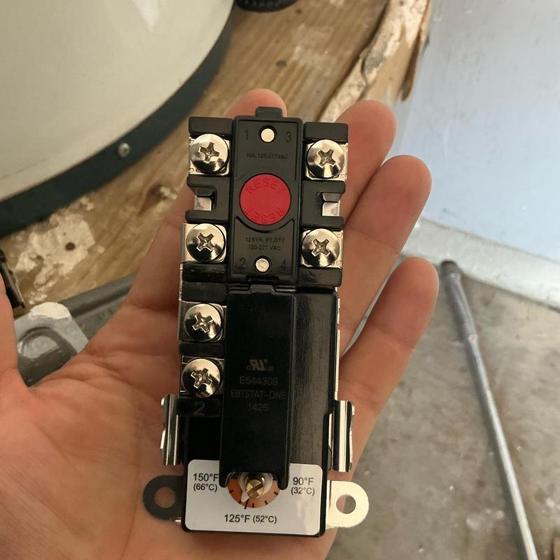 Water heater thermostat being held for replacement in hand Water heater thermostat being held for replacement in hand