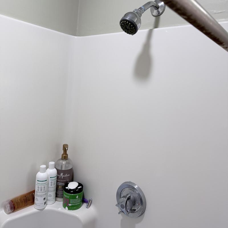 Shower valve and showerhead in white tub surround Shower valve and showerhead in white tub surround