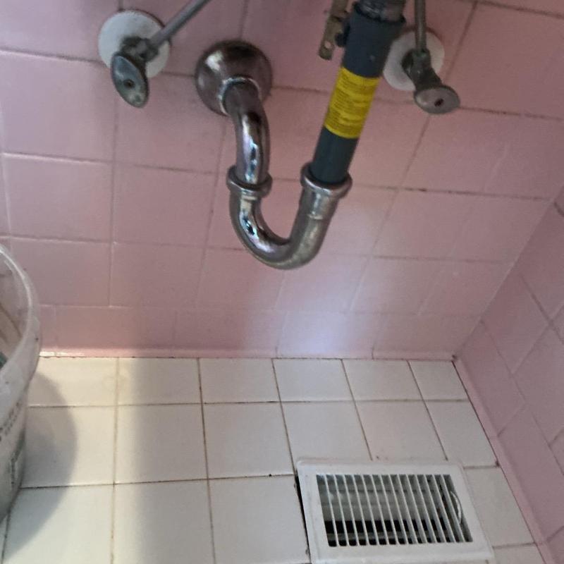 Sink drain pipe under pink bathroom wall tiles Sink drain pipe under pink bathroom wall tiles