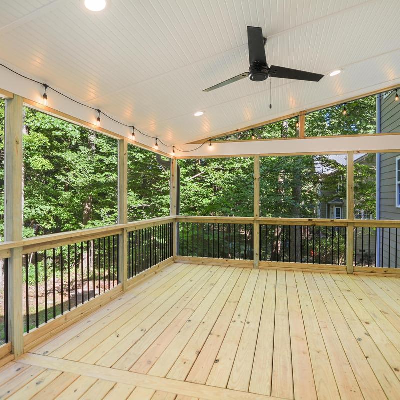 Screened porch with wood flooring and ceiling fan
