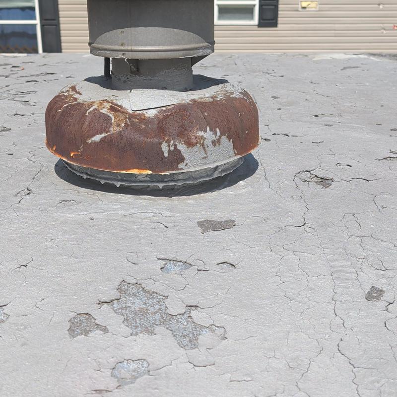 Metal mobile home roof with rust and coating damage