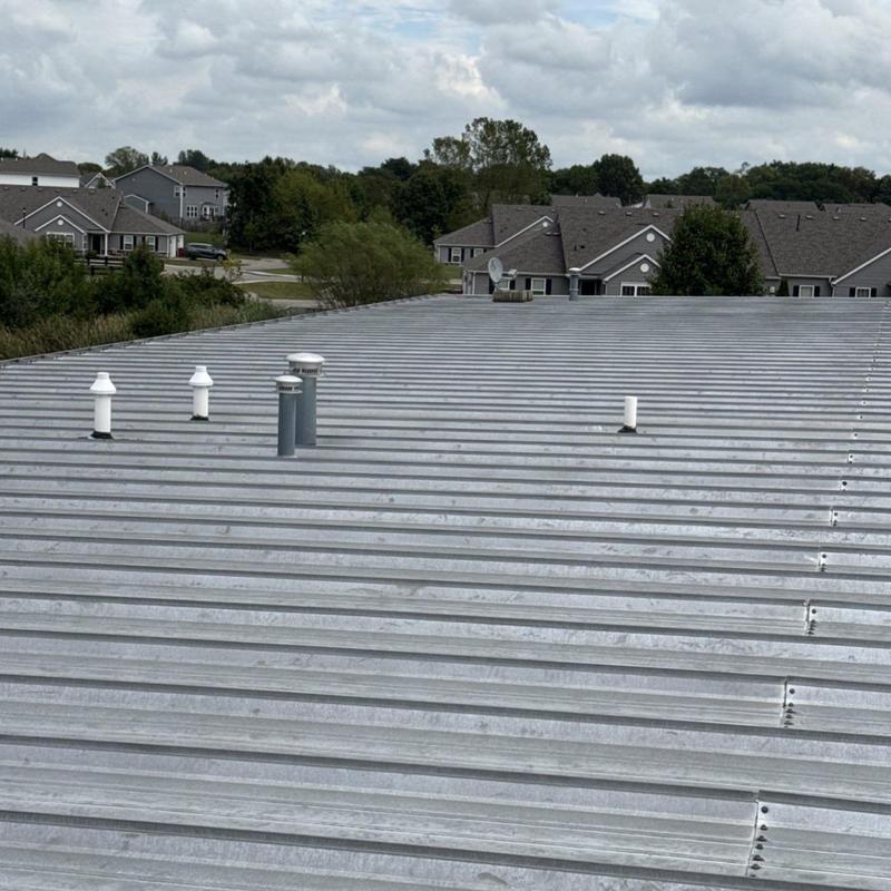 Metal commercial roof with vent pipes and leak areas