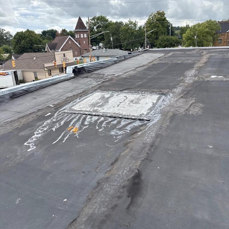 EPDM rubber low slope roof with patch and wear marks
