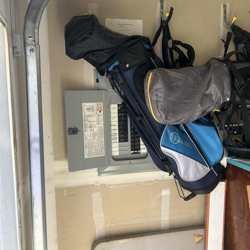Electrical service panel with golf bags stored nearby Electrical service panel with golf bags stored nearby