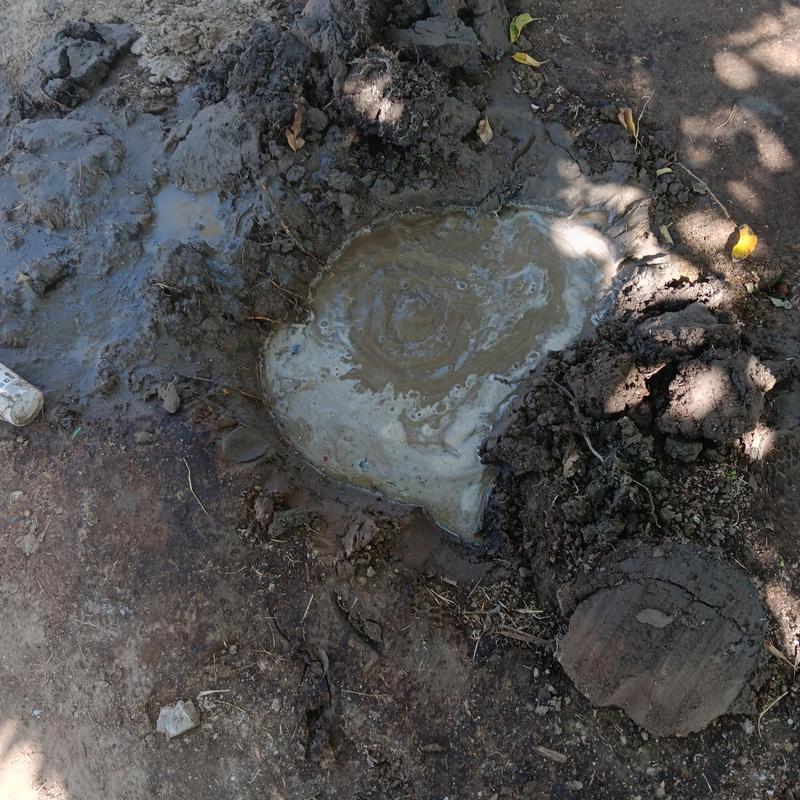 Burst water main leak with muddy water pooling outdoors Burst water main leak with muddy water pooling outdoors