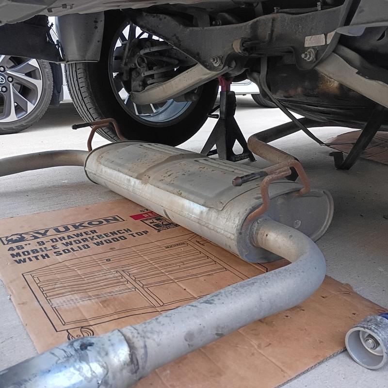 Exhaust muffler removed during car repair undercarriage Exhaust muffler removed during car repair undercarriage