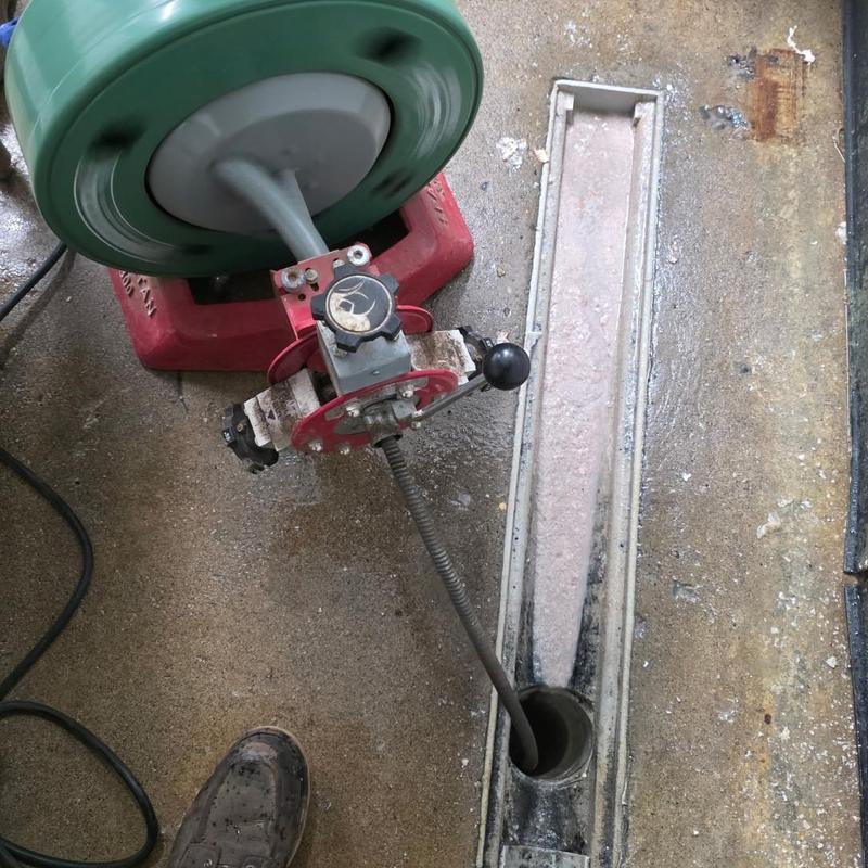 Drain auger clearing floor drain line in concrete floor Drain auger clearing floor drain line in concrete floor