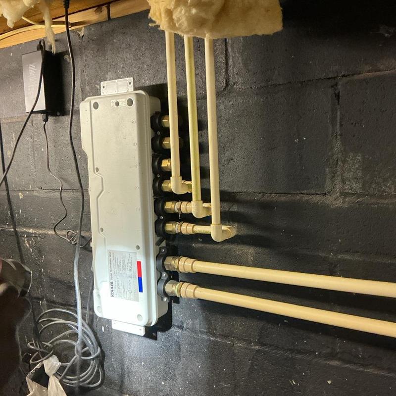 Manifold with connected pipes in basement wall Manifold with connected pipes in basement wall