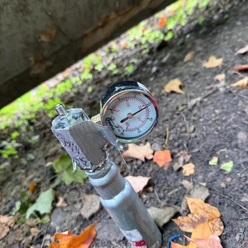 Propane tank pressure gauge outdoors with tape repair
