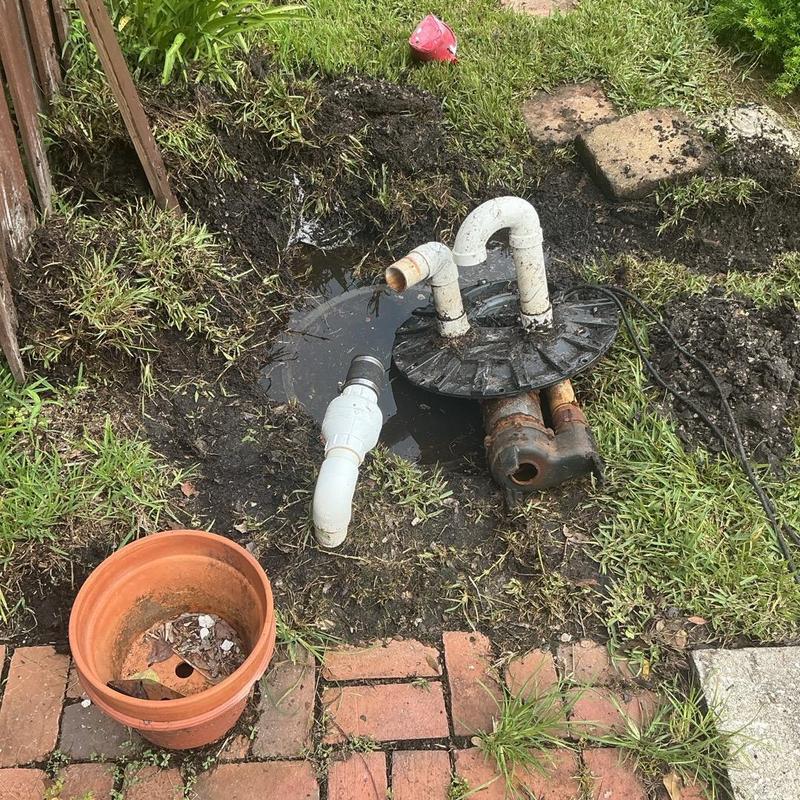 Yard drainage pump with exposed piping in muddy yard Yard drainage pump with exposed piping in muddy yard