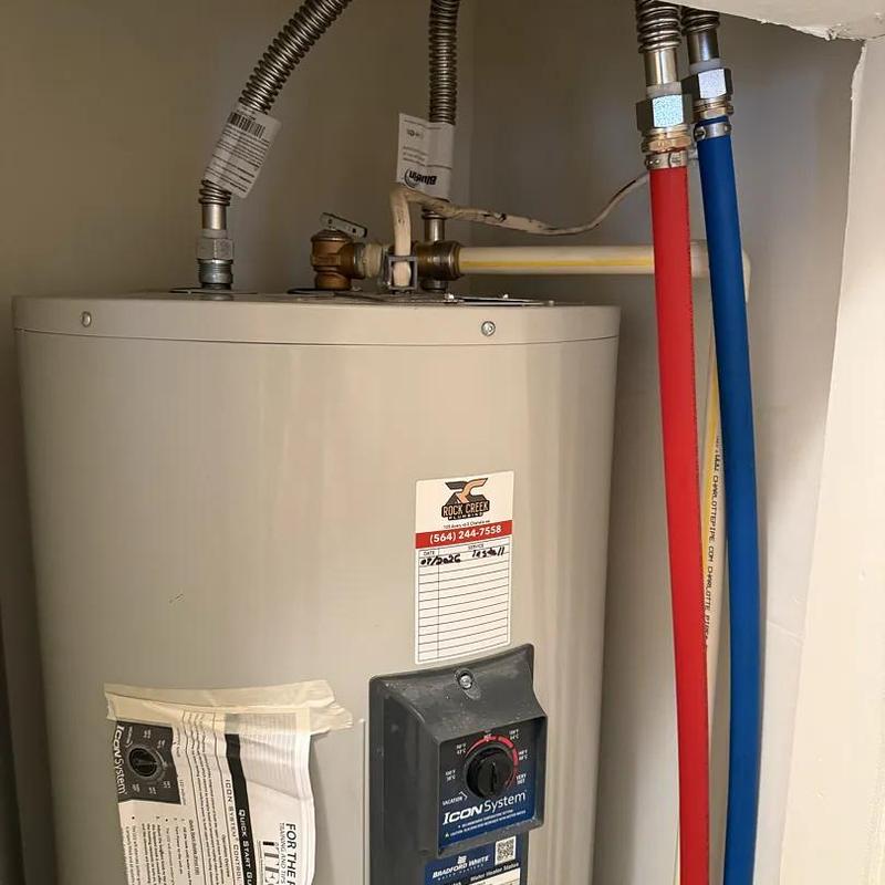 Water heater installation with supply and drain connections Water heater installation with supply and drain connections