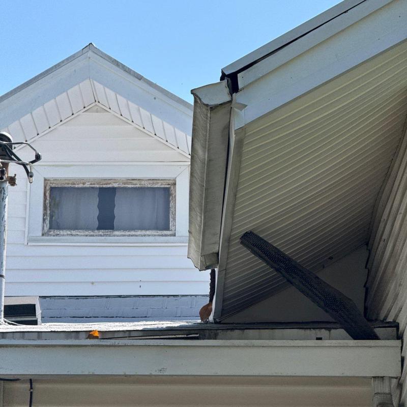 Gutter system damage and bent downspout on house exterior