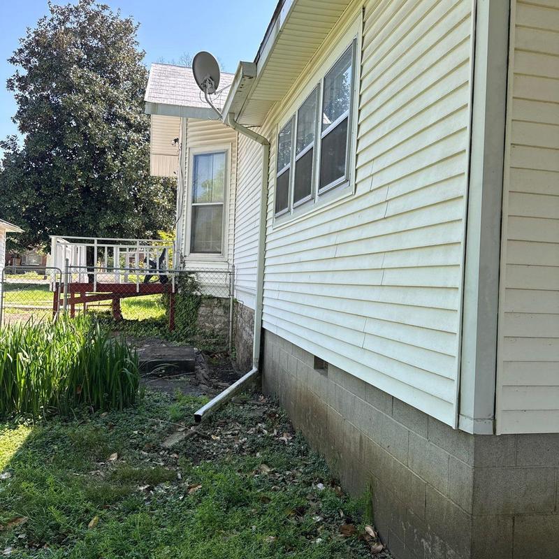 Vinyl siding with drainpipe and foundation wall exterior