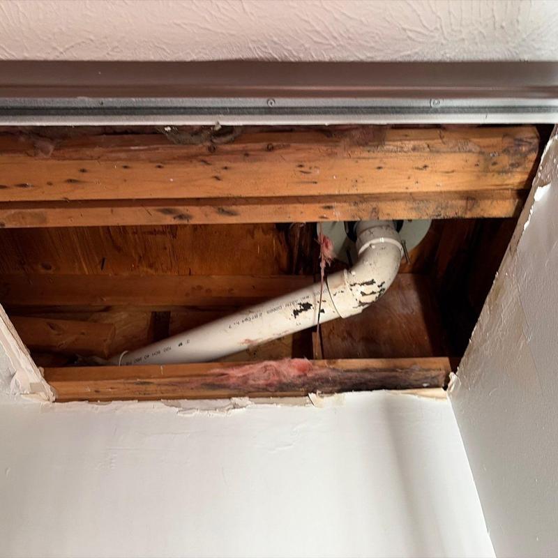 PVC drain pipe with ceiling access hole and wood framing