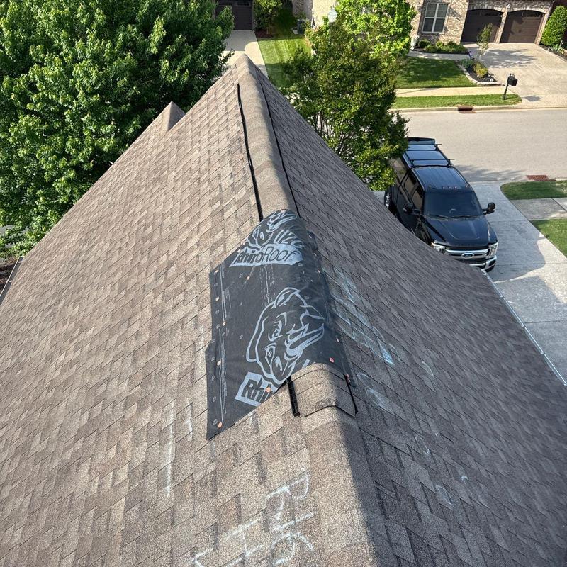 Asphalt shingle roof with hail damage and underlayment exposed