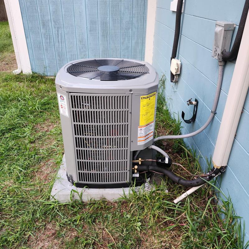 2-ton 14 SEER2 AC condenser unit outside blue house 2-ton 14 SEER2 AC condenser unit outside blue house
