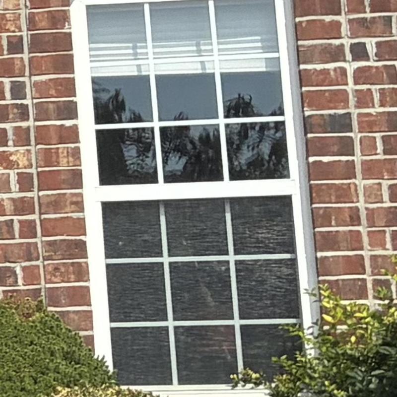 Front windows with hail damage on brick house