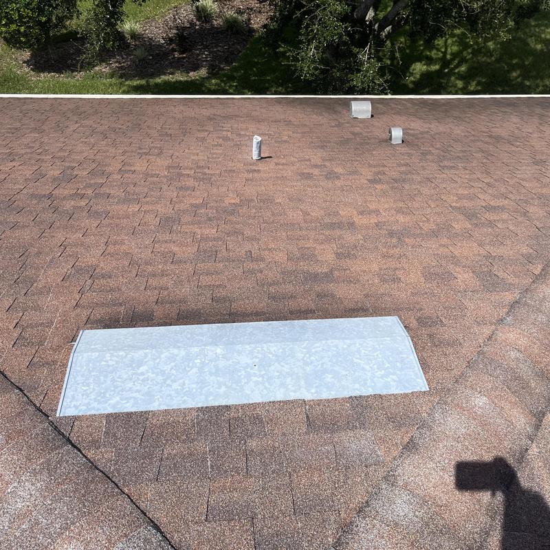 Shingle roof with metal flashing patch on vent area Shingle roof with metal flashing patch on vent area