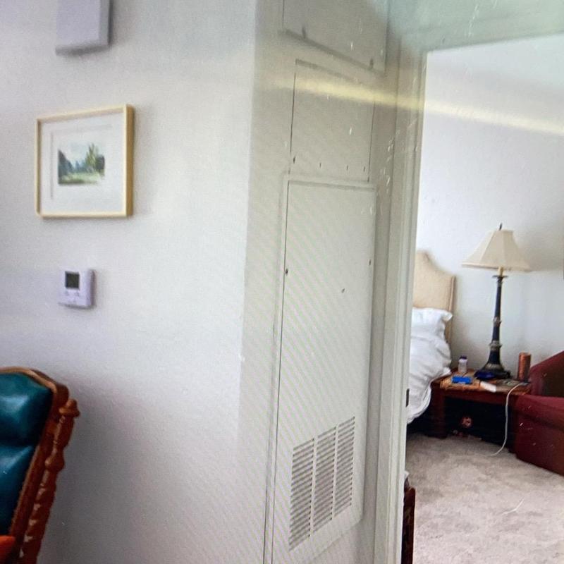 Indoor air handler unit with vent panel in home room Indoor air handler unit with vent panel in home room