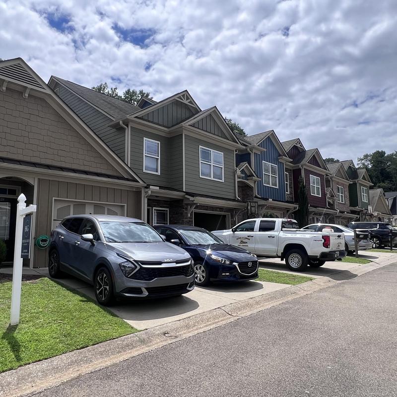 Townhome complex exterior with parked vehicles