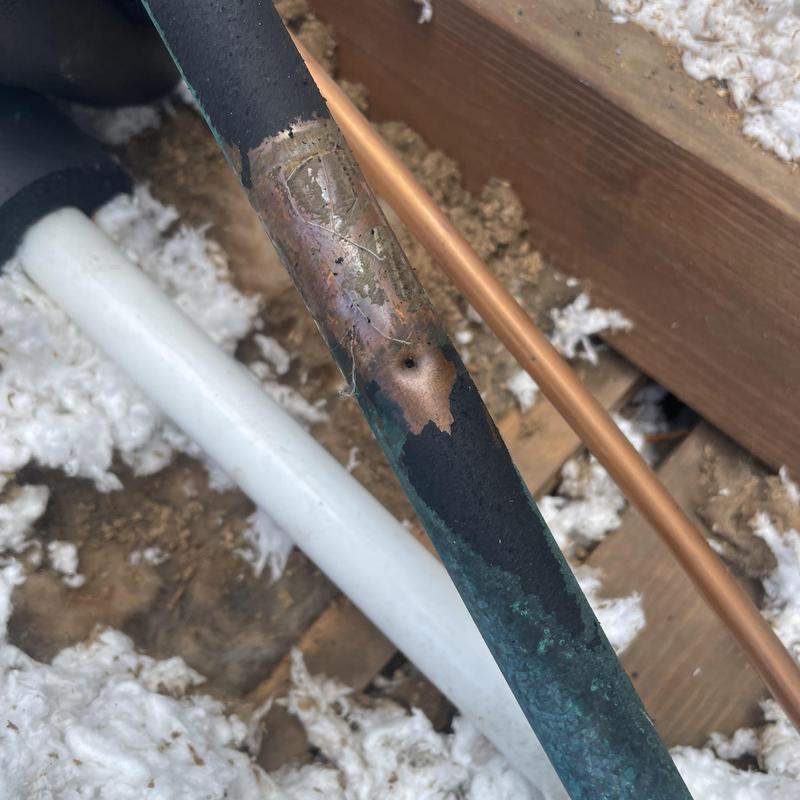 Copper refrigerant line showing corrosion and leak damage Copper refrigerant line showing corrosion and leak damage
