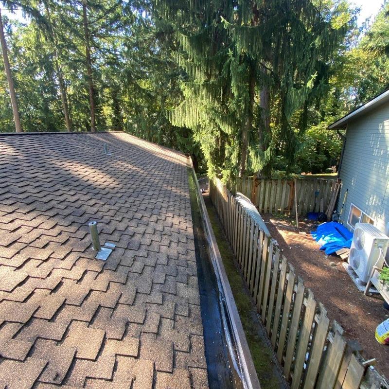 Gutter system cleaning and leaf removal on roof edge