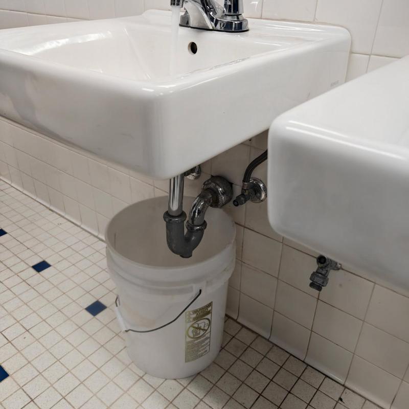 Sink drain trap with bucket in commercial bathroom Sink drain trap with bucket in commercial bathroom