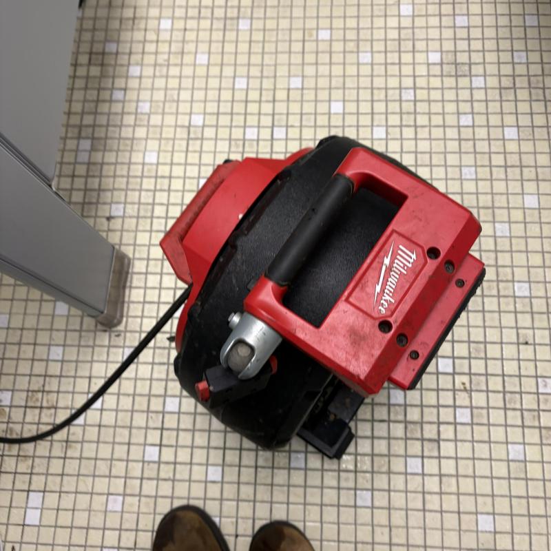 Sewer drain cleaning machine on tiled floor Sewer drain cleaning machine on tiled floor
