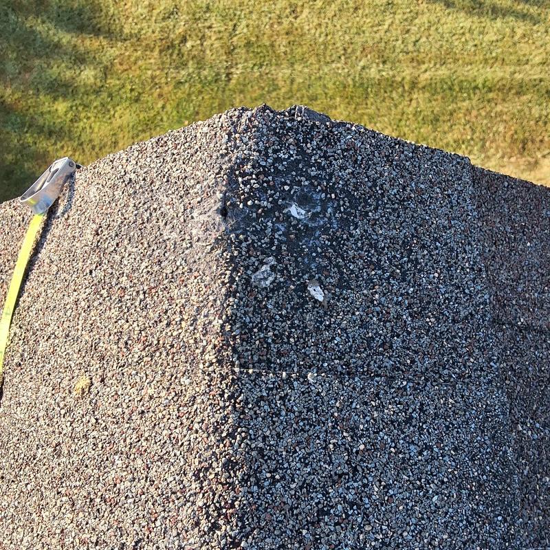Roof dormer shingle damage close-up with granule loss Roof dormer shingle damage close-up with granule loss