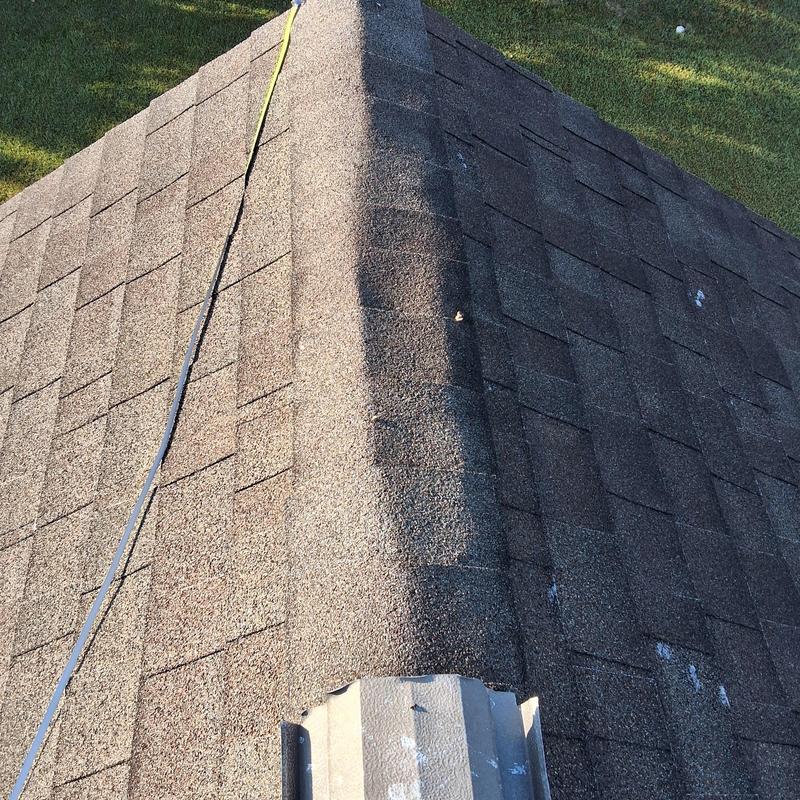 Asphalt shingle roof ridge with visible wear and damage Asphalt shingle roof ridge with visible wear and damage