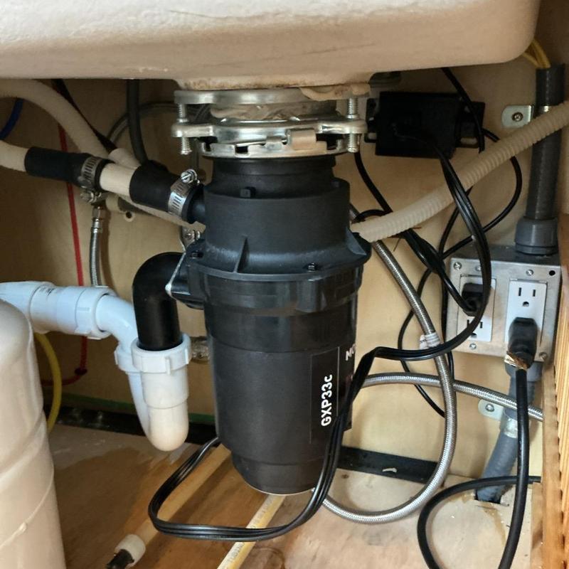 Garbage disposal unit under kitchen sink with plumbing Garbage disposal unit under kitchen sink with plumbing