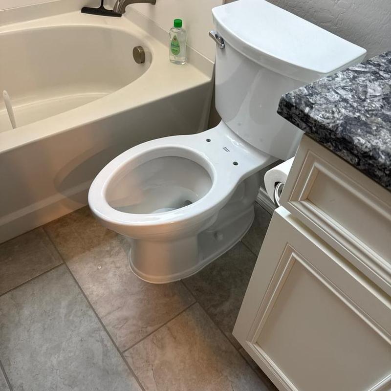 Toilet bowl installed next to bathtub and vanity