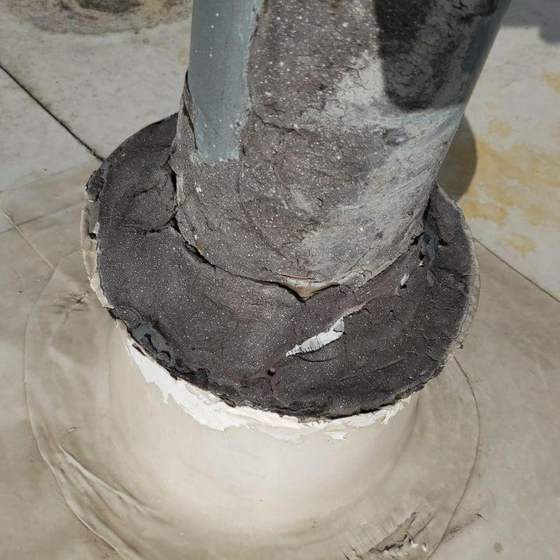 Flat roof pipe jack with cracked sealant and damage