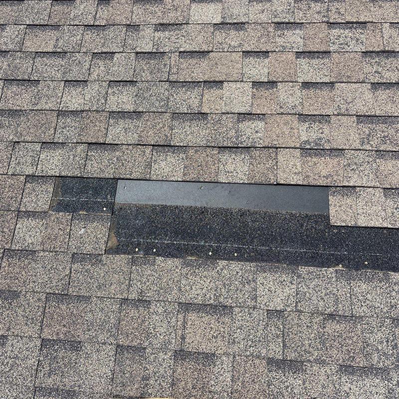 Asphalt shingles with missing piece during roof inspection