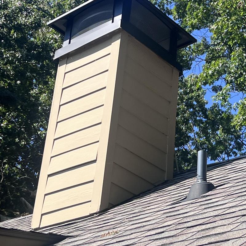 Custom chimney cap and siding on roof shingles