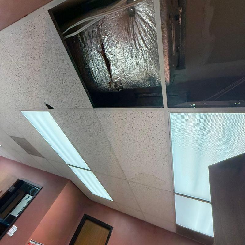 Ceiling tiles with water damage and insulation exposed