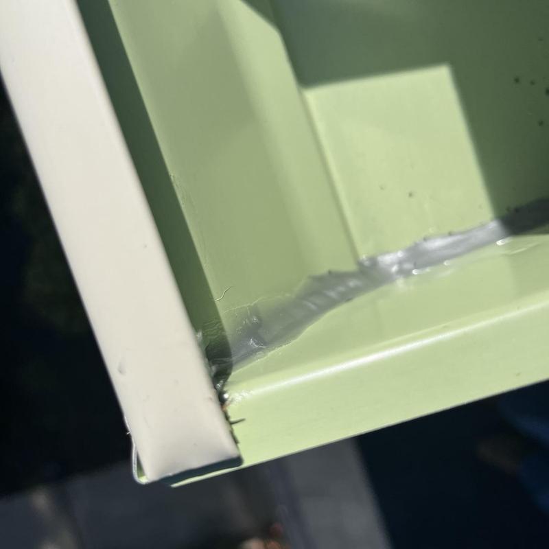 Aluminum gutter corner sealed with clear caulk