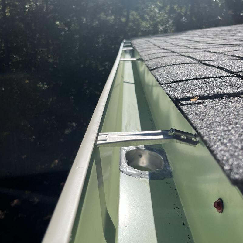 Aluminum gutter with repaired flashing and roof edge