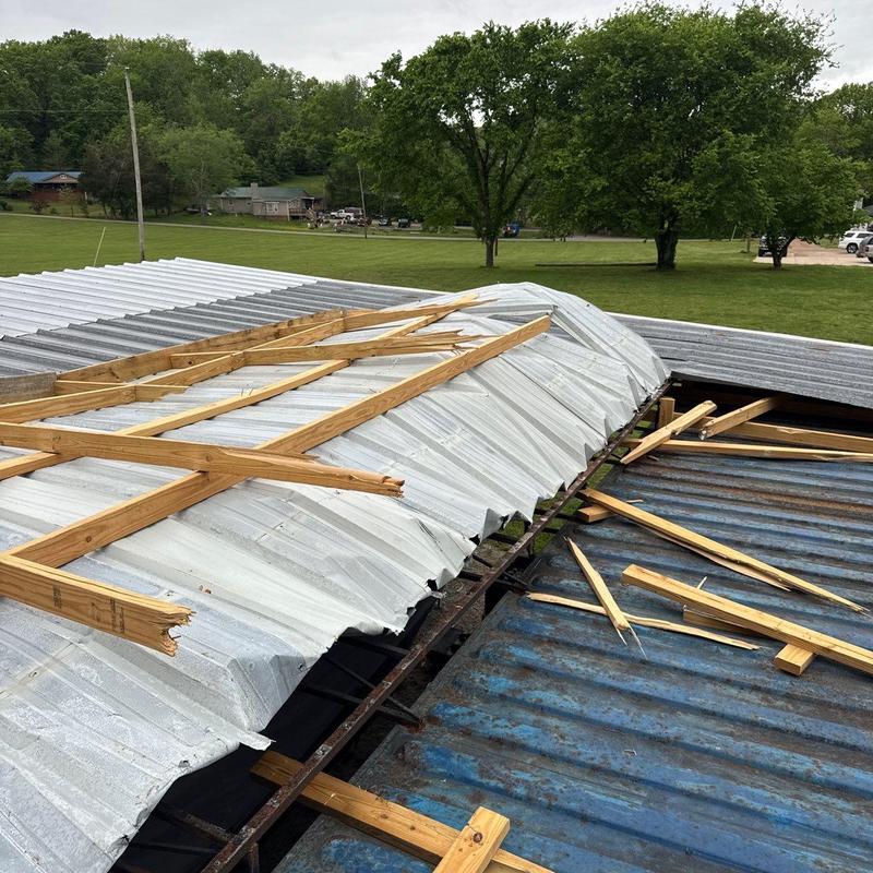 Metal roofing panels with broken wooden supports