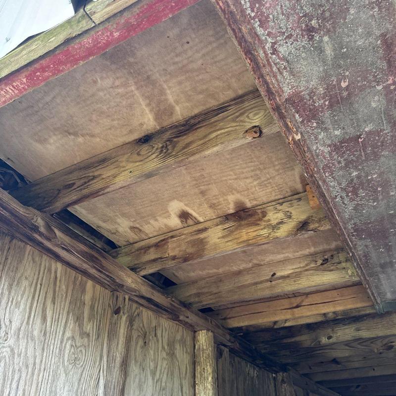 Wooden ceiling beams with water damage and staining