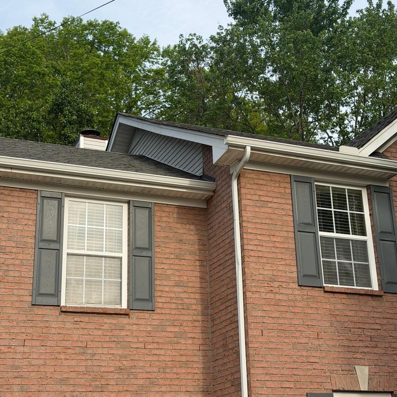 Roof shingles and gutter system on brick house exterior