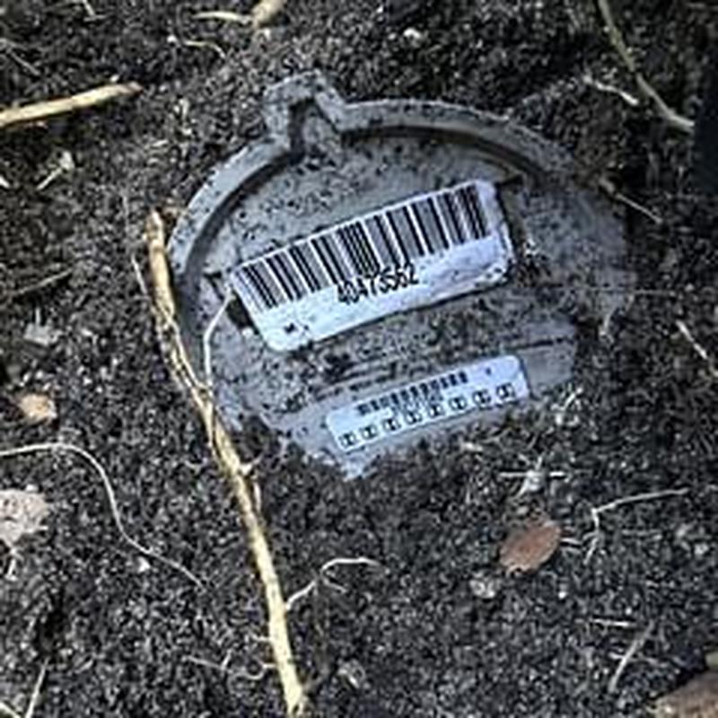 Wilkins 975XL meter partially buried in soil