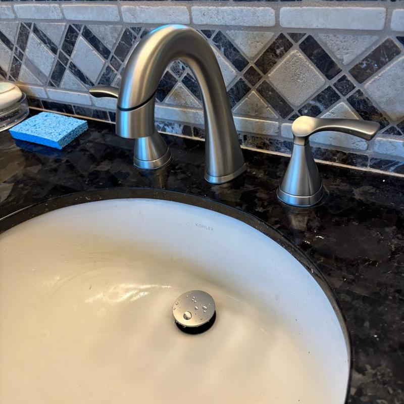 Widespread bathroom faucet installation on granite countertop