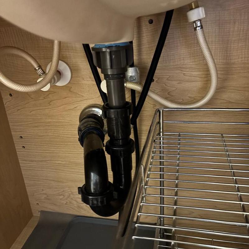 Sink drain pipes and water supply lines under cabinet
