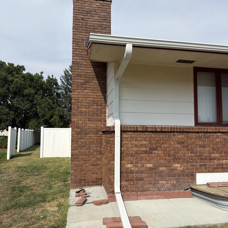 White aluminum gutters on brick house corner White aluminum gutters on brick house corner