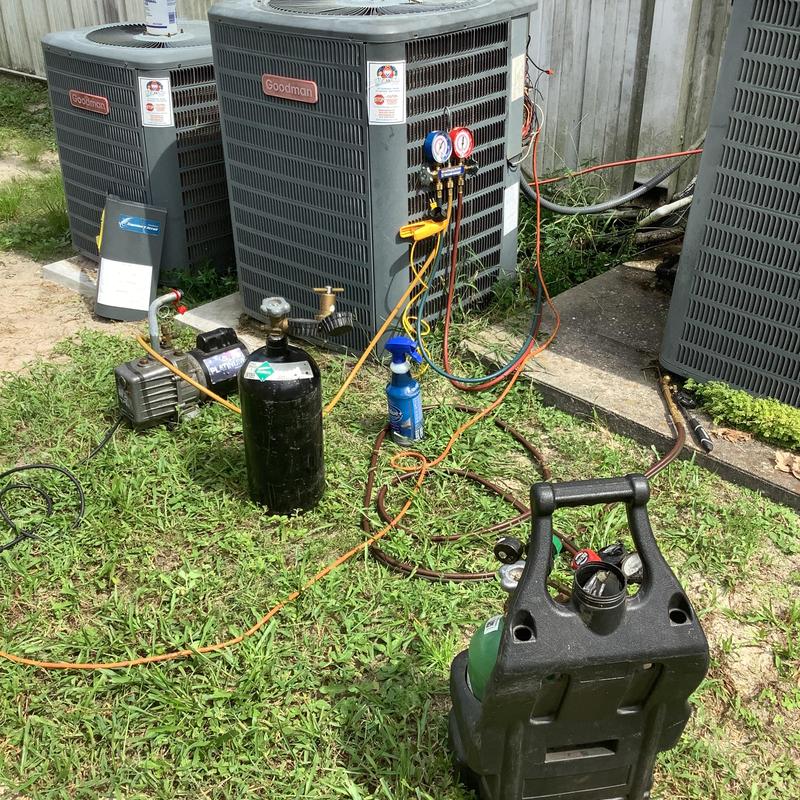 Commercial AC units with gauges and refrigerant tanks during service Commercial AC units with gauges and refrigerant tanks during service