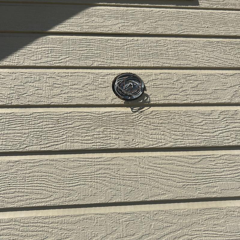 Exterior electrical wiring setup on beige siding wall Exterior electrical wiring setup on beige siding wall