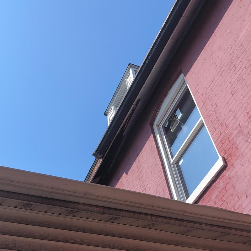 Damaged soffit and gutters on residential roof edge